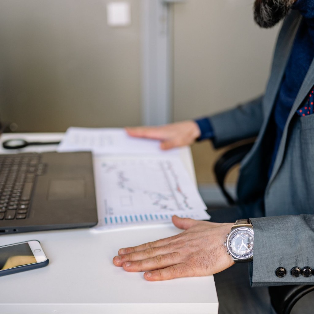 A person reviewing security reports beside a laptop